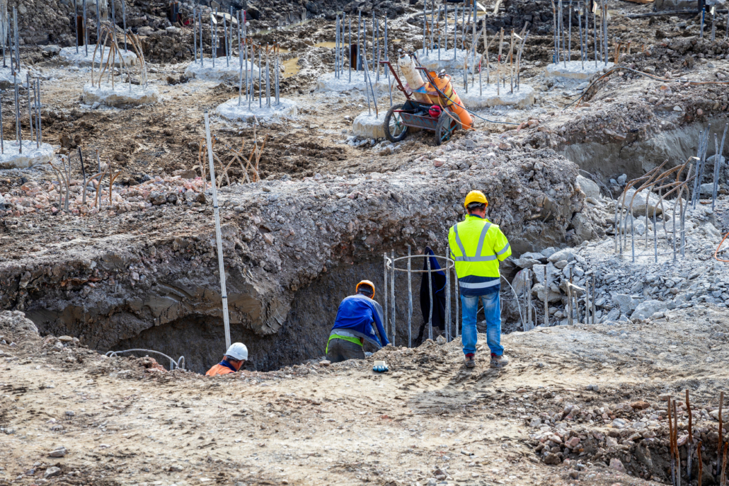 Construction workers practicing jobsite fire prevention and underground utility safety during excavation.